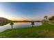 Tranquil lake view at sunset, with palm trees at 18187 W Wind Song Ave, Goodyear, AZ 85338