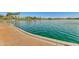 Serene view of a sparkling lake with palm trees at 18187 W Wind Song Ave, Goodyear, AZ 85338