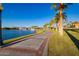 Brick walkway along the lake with palm trees and fountains at 18187 W Wind Song Ave, Goodyear, AZ 85338