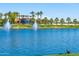 Scenic lakefront community with palm trees, fountains, and walking paths at 18187 W Wind Song Ave, Goodyear, AZ 85338