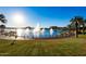 Curved walking path around a lake with fountains and palm trees at 18187 W Wind Song Ave, Goodyear, AZ 85338