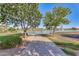 Peaceful lakeside walkway with scenic views and lush landscaping at 18187 W Wind Song Ave, Goodyear, AZ 85338