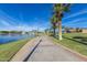 Paved walkway along the lake with palm trees and lighting at 18187 W Wind Song Ave, Goodyear, AZ 85338