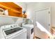 Bright laundry room with washer, dryer, and extra shelving at 18187 W Wind Song Ave, Goodyear, AZ 85338