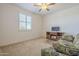 Bright bedroom with window shutters, carpet, and a comfy couch at 18439 W Wind Song Ave, Goodyear, AZ 85338