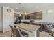 Modern kitchen with dark wood cabinets, granite countertops, and an island at 18439 W Wind Song Ave, Goodyear, AZ 85338