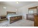 Main bedroom with wood platform bed and en suite bathroom at 18439 W Wind Song Ave, Goodyear, AZ 85338