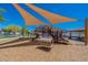 Shaded playground with modern play equipment and wood-chip surface at 18439 W Wind Song Ave, Goodyear, AZ 85338