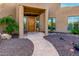 Elegant entryway with a wood door, stone flooring and desert landscaping at 19007 E Lazo Ct, Rio Verde, AZ 85263