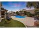 Relaxing backyard featuring a beautiful pool, lush greenery, and a hanging chair at 20744 W Hamilton St, Buckeye, AZ 85396