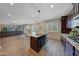 Open concept kitchen with island, granite counters, and views into living room at 20744 W Hamilton St, Buckeye, AZ 85396