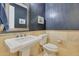 Elegant powder room with dark walls and a pedestal sink at 20882 W Eastview Way, Buckeye, AZ 85396