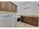 Laundry room with wood cabinets and modern appliances at 20882 W Eastview Way, Buckeye, AZ 85396