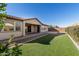 Artificial turf backyard with covered patio and walkway at 21160 E Cattle Dr, Queen Creek, AZ 85142