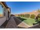 Landscaped backyard with artificial turf and paved pathway at 21160 E Cattle Dr, Queen Creek, AZ 85142