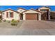 Charming house with a two-car garage, mature landscaping, and a brick driveway at 21160 E Cattle Dr, Queen Creek, AZ 85142