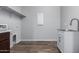 Laundry room with sink, cabinets, and shelving at 21160 E Cattle Dr, Queen Creek, AZ 85142