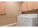 Bright laundry room with washer, dryer, and ample cabinets at 213 E Summerside Rd, Phoenix, AZ 85042