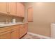 Laundry room with light wood cabinets and granite countertop at 213 E Summerside Rd, Phoenix, AZ 85042