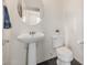 Clean bathroom with pedestal sink, toilet and dark tile floor at 2413 E Alta Vista Rd, Phoenix, AZ 85042