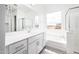 Bright bathroom featuring a double vanity, soaking tub, and separate glass-enclosed shower at 25505 W Brookhart Way, Wittmann, AZ 85361