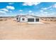 New construction white stucco home features a three-car garage and desert landscape at 25505 W Brookhart Way, Wittmann, AZ 85361