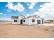 Inviting white stucco home featuring a three-car garage and desert landscape at 25505 W Brookhart Way, Wittmann, AZ 85361