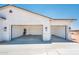 A spacious, three-car garage with modern lighting and doors and newly-poured concrete pad at 25505 W Brookhart Way, Wittmann, AZ 85361