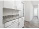 Kitchenette features granite countertops and white cabinets, creating a stylish space at 25505 W Brookhart Way, Wittmann, AZ 85361