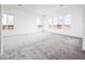 Spacious living room with soft gray carpet and bright natural light at 25505 W Brookhart Way, Wittmann, AZ 85361