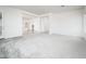Bright, open living room with neutral carpet, leading into the kitchen and dining area at 25505 W Brookhart Way, Wittmann, AZ 85361