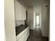 Walk-in pantry with white cabinets and granite countertop, leading to the hallway at 25505 W Brookhart Way, Wittmann, AZ 85361