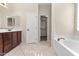 Bathroom with double sinks, tiled floors, bathtub, and walk-in closet at 2742 N Augustine --, Mesa, AZ 85207