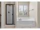 Bright bathroom featuring a tub, shower, and window with plantation shutters at 2742 N Augustine --, Mesa, AZ 85207