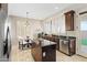 Bright kitchen with dark wood cabinets, stainless appliances, and island with granite countertop next to a dining nook at 2742 N Augustine --, Mesa, AZ 85207