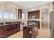 Stylish kitchen featuring dark wood cabinets, stainless steel appliances, granite counters and a center island at 2742 N Augustine --, Mesa, AZ 85207