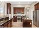 Kitchen boasts dark wood cabinets, a center island, stainless steel appliances, and open layout at 2742 N Augustine --, Mesa, AZ 85207