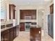 Well-lit kitchen featuring dark wood cabinets, granite countertops, stainless steel appliances, and an island at 2742 N Augustine --, Mesa, AZ 85207