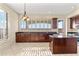 Well-lit kitchen featuring dark wood cabinets, granite countertops, an island, and stainless steel appliances at 2742 N Augustine --, Mesa, AZ 85207