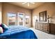 Bedroom with a blue comforter, dresser and access to a balcony at 28990 N White Feather Ln # 130, Scottsdale, AZ 85262