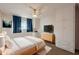 Cozy bedroom with wood-look floors, built-in wardrobe, and a window with curtains at 3249 W Maryland Ave, Phoenix, AZ 85017