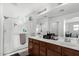 Bathroom with double sinks, wooden cabinets, a glass-enclosed shower, and mirrors at 3451 E Tyson St, Gilbert, AZ 85295