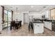 Well-lit kitchen with stainless steel appliances, an island with seating and dining table at 3451 E Tyson St, Gilbert, AZ 85295