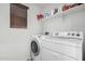 Well-equipped laundry room with a washer, dryer, window and storage shelf at 3451 E Tyson St, Gilbert, AZ 85295