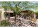 Landscaped backyard with pergola, stone seating, and mature trees at 3554 N Hooper St, Buckeye, AZ 85396