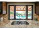 Kitchen sink with granite countertop overlooks a sparkling pool and backyard at 4027 E Pueblo Ave, Mesa, AZ 85206