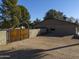 Private side yard with wooden gate and mature trees at 4027 E Pueblo Ave, Mesa, AZ 85206