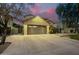 Two-story house with a three-car garage and well-manicured lawn at dusk at 4332 E Vallejo Ct, Gilbert, AZ 85298