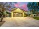 View of the front exterior featuring the garage and inviting entryway at dusk at 4332 E Vallejo Ct, Gilbert, AZ 85298