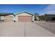 A light green single story home with a two-car garage and nicely landscaped yard at 4938 W Michelle Dr, Glendale, AZ 85308